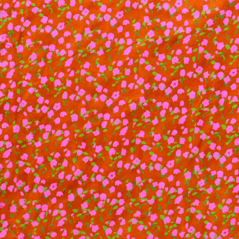 feuille de papier lokta fabriquée au népal avec un motif de petites fleurs sur fond orange